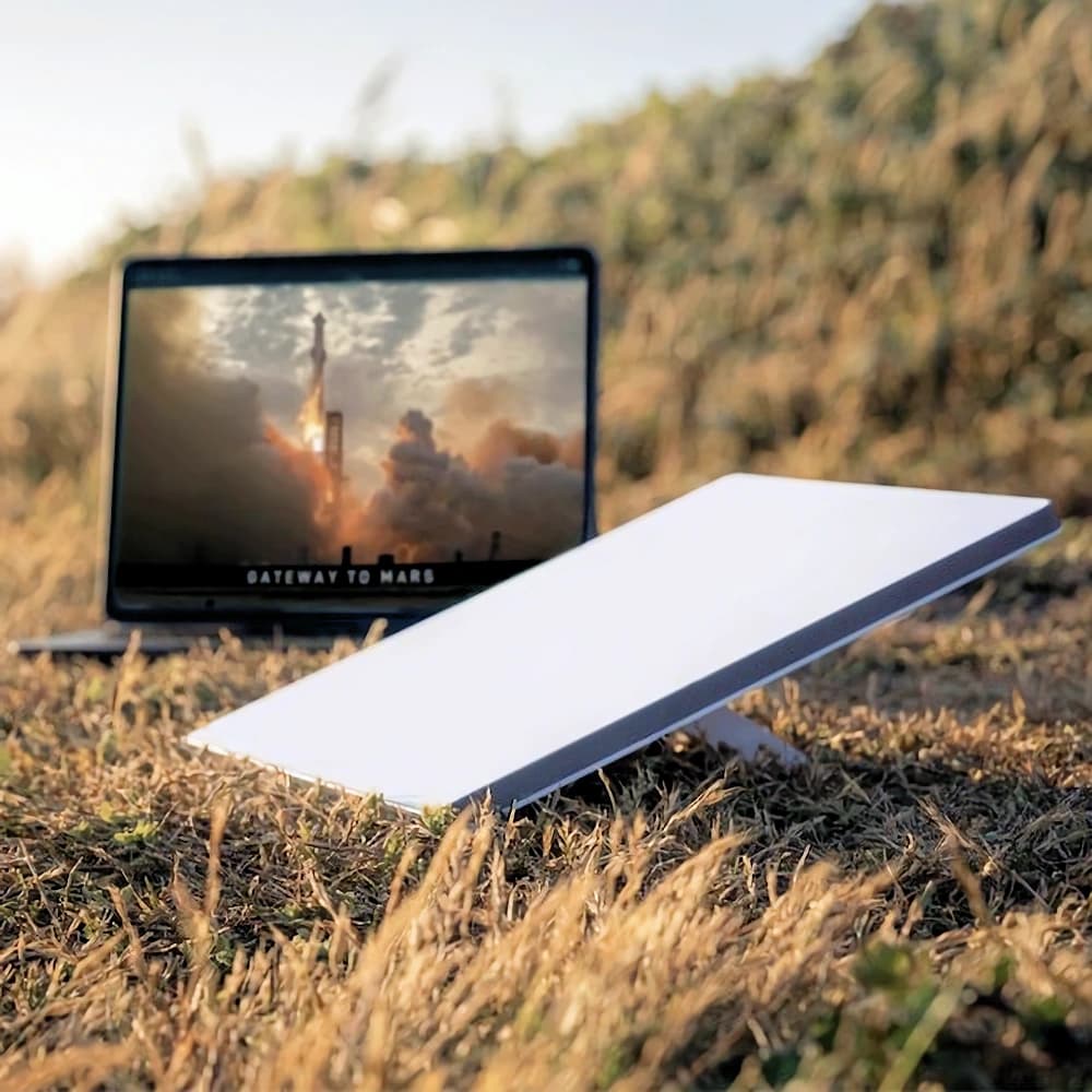 Starlink Mini set up outdoors beside a laptop